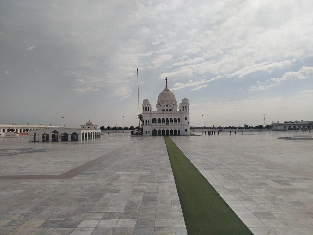 Majestic white dome and courtyard of Gurdwara Darbar Sahib Kartarpur in Pakistan, a primary Sikh pilgrimage site.